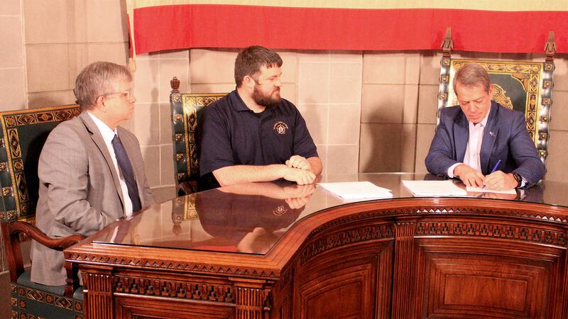 Gov. Jim Pillen, right, signs an agreement with Nebraska's correctional facility workers on...